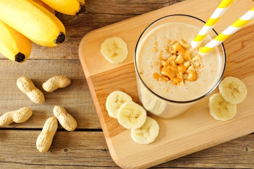 Peanut Butter Banana Smoothie in Glass Cup with Yellow Straw
    