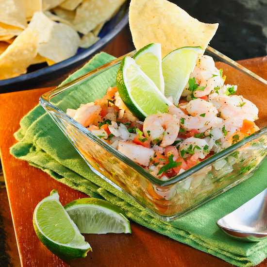 Mango Shrimp Ceviche in Clear Glass Bowl next to Tortilla Chips