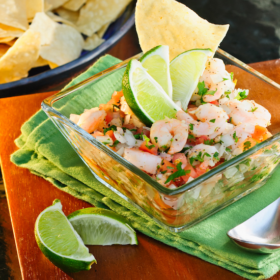 Ceviche de camarones y mango en tazón de cristal transparente junto a totopos