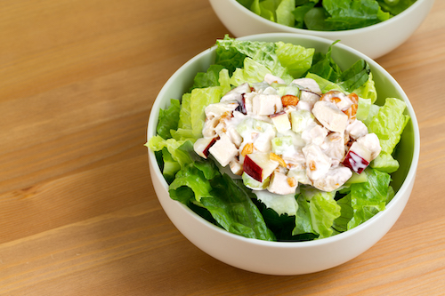 Ensalada verde con ensalada de pollo preparada en tazón blanco