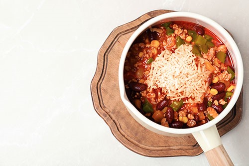 Burrito Stew in White Pot topped with cheese